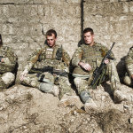 Soldiers learning against a wall in afghanistan