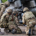 Armourers re-arm a 656 Sqn, 4 Regt AAC Apache D with Hellfire AGM-114N Air-to-surface Missiles during Exercise SPRING STORM 23 at a live fire coastal range in Estonia
